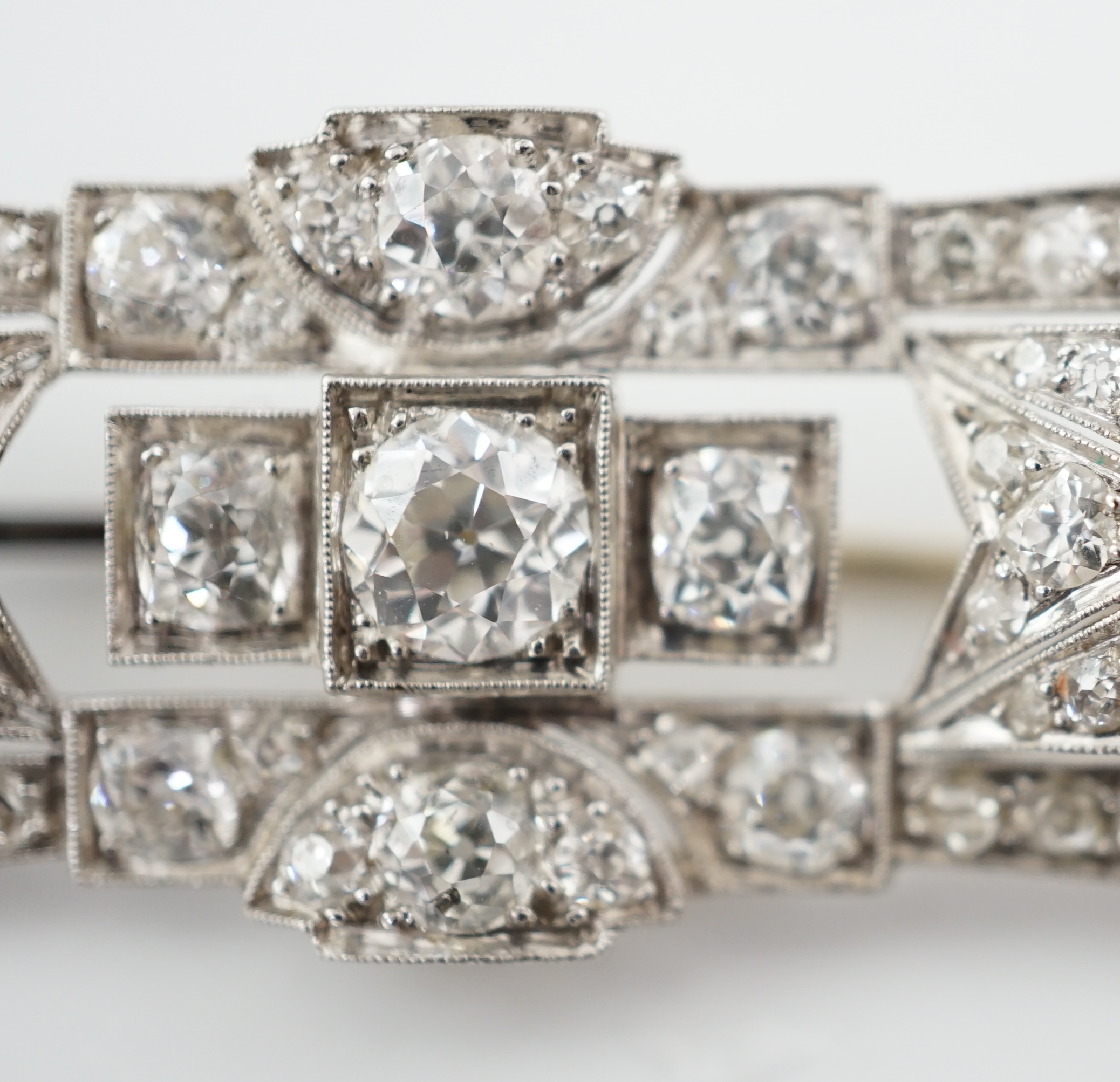 An Art Deco platinum and millegrain set diamond cluster brooch